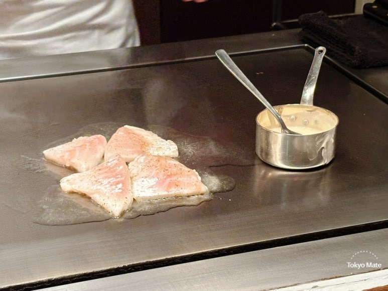 Sea bream being seared on the iron griddle