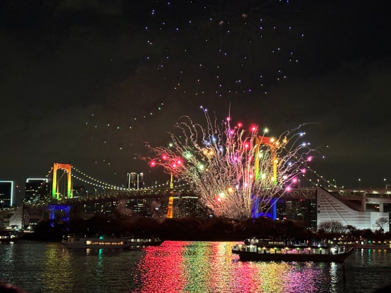Rainbow Bridge illuminated at night with Tokyo Tower in background