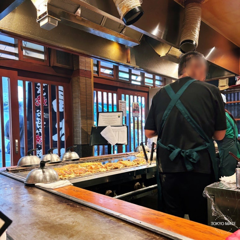 Okonomiyaki being grilled on the teppan at Fukutaro main store