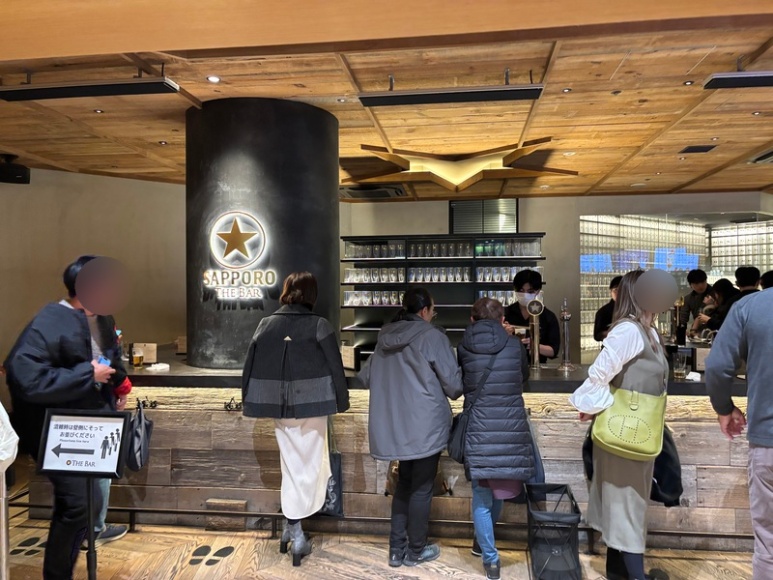 Customers standing at the counter inside Sapporo The Bar Ginza