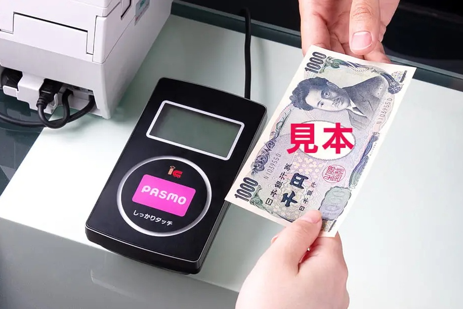 Topping up an iPhone Pasmo with cash at a convenience store counter in Japan