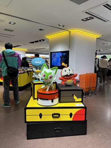 In-store display of Sprigatito, Quaxly and Fuecoco on a Pikachu suitcase