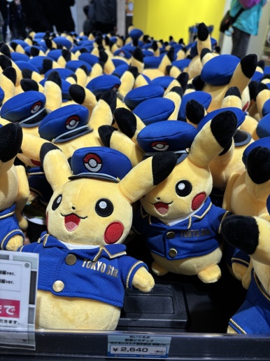 Rows of stationmaster Pikachu plush toys in blue TOKYO STA uniforms