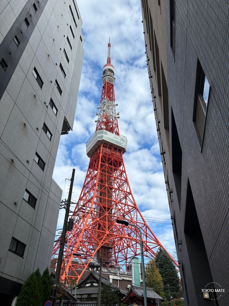 Tokyo Tower visible through a narrow gap between residential buildings in Higashiazabu