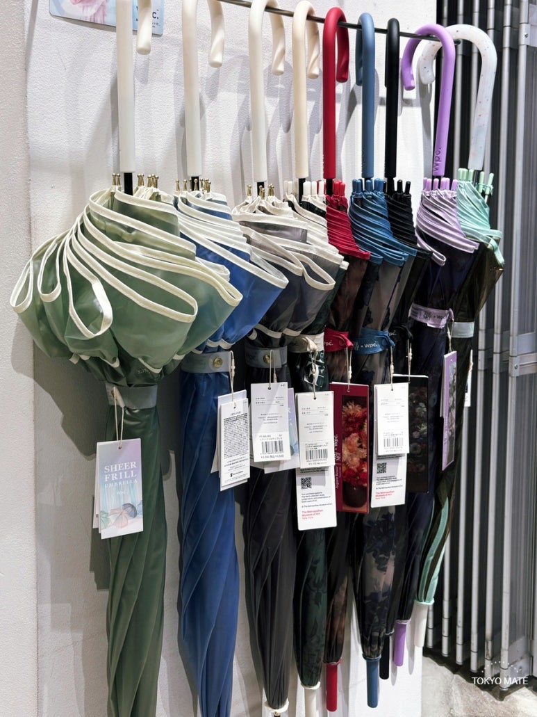 Wpc. SHEER FRILL UMBRELLA and other long umbrellas in a store lineup
